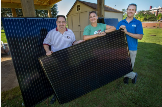 three people with solar panel